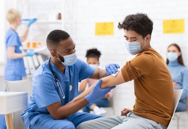 戴面具的年轻人正在接种疫苗
